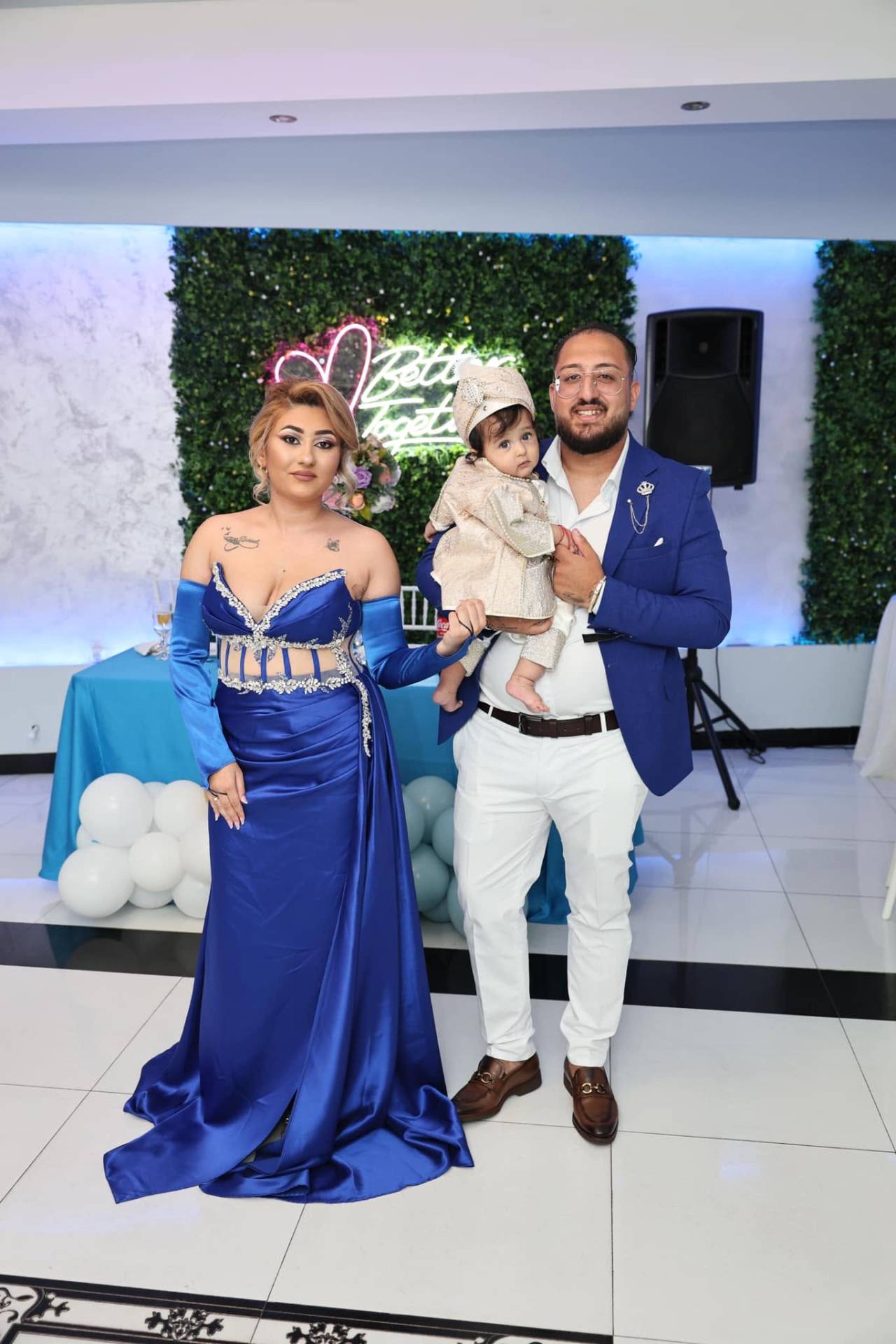 Părinți eleganți cu bebelușul în costum aurit